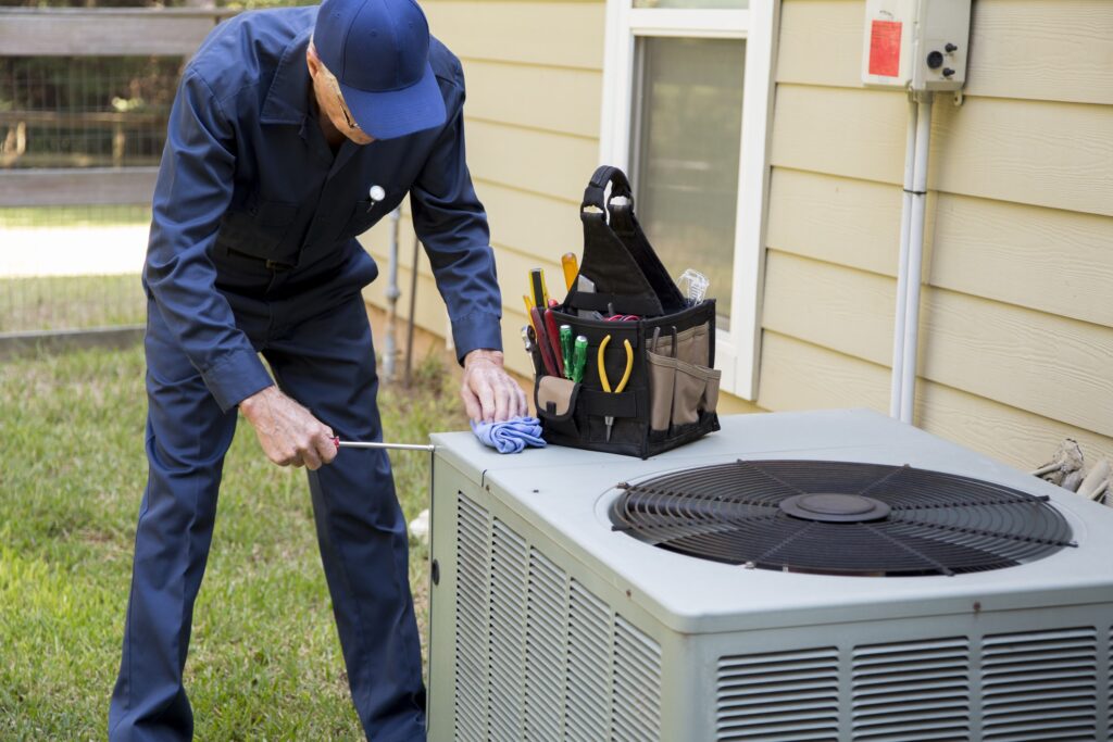Senior Adult air conditioner Technician services outdoor unit.