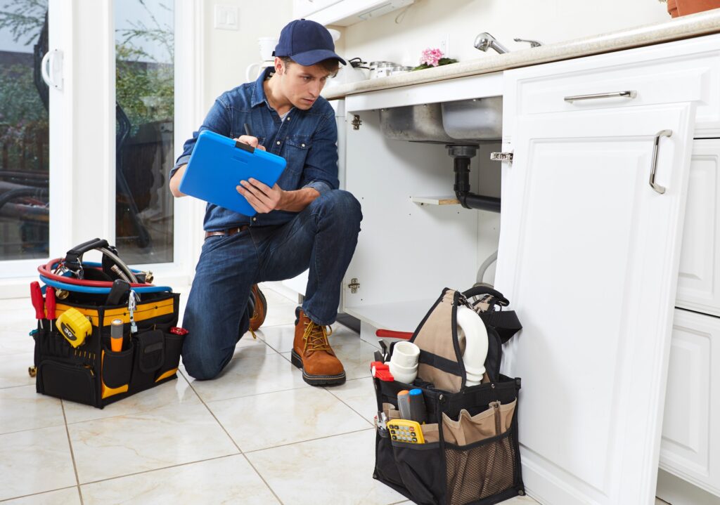Professional plumber doing renovation in the kitchen of a home.